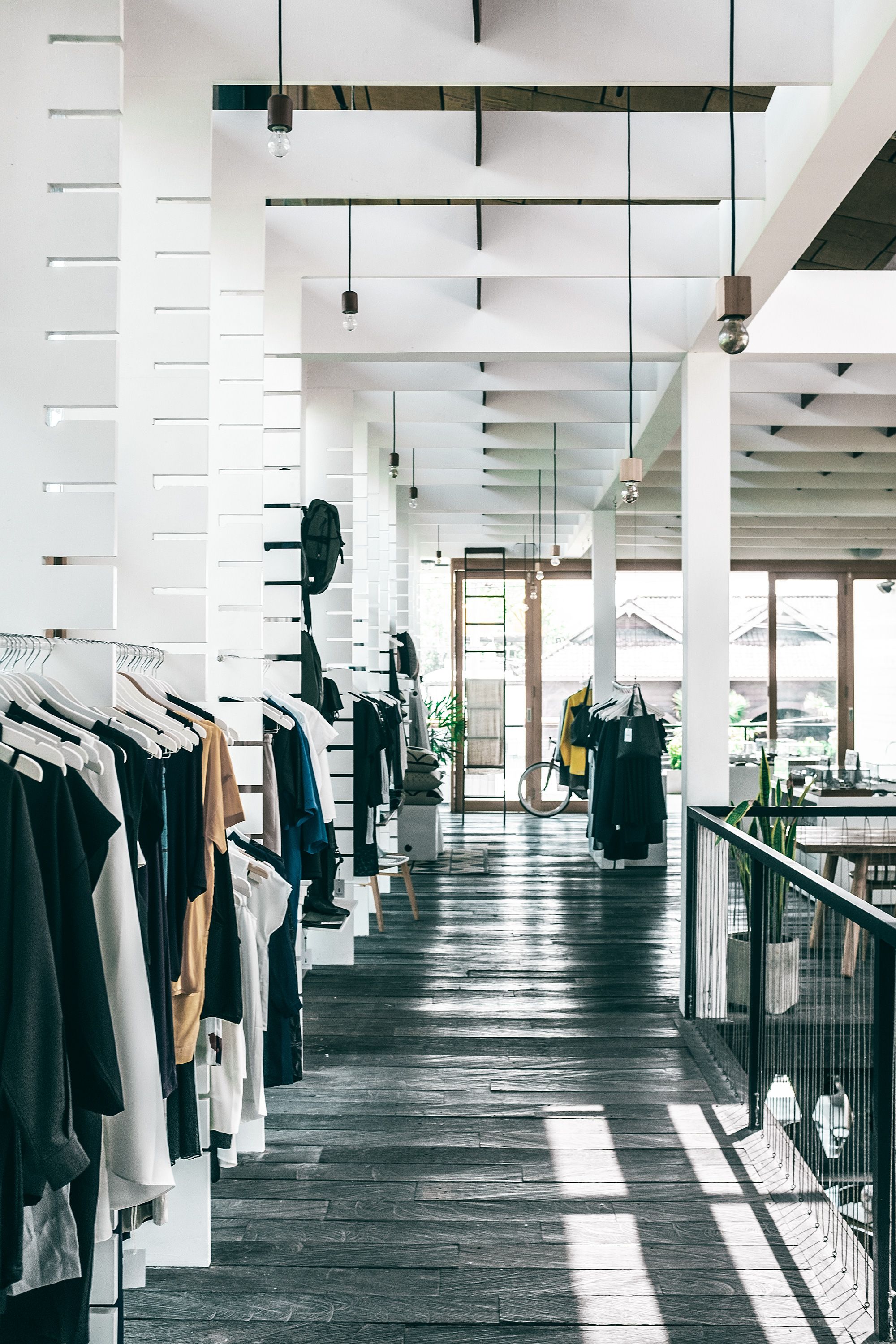 A contemporary fashion boutique with garments arranged for retail customers.