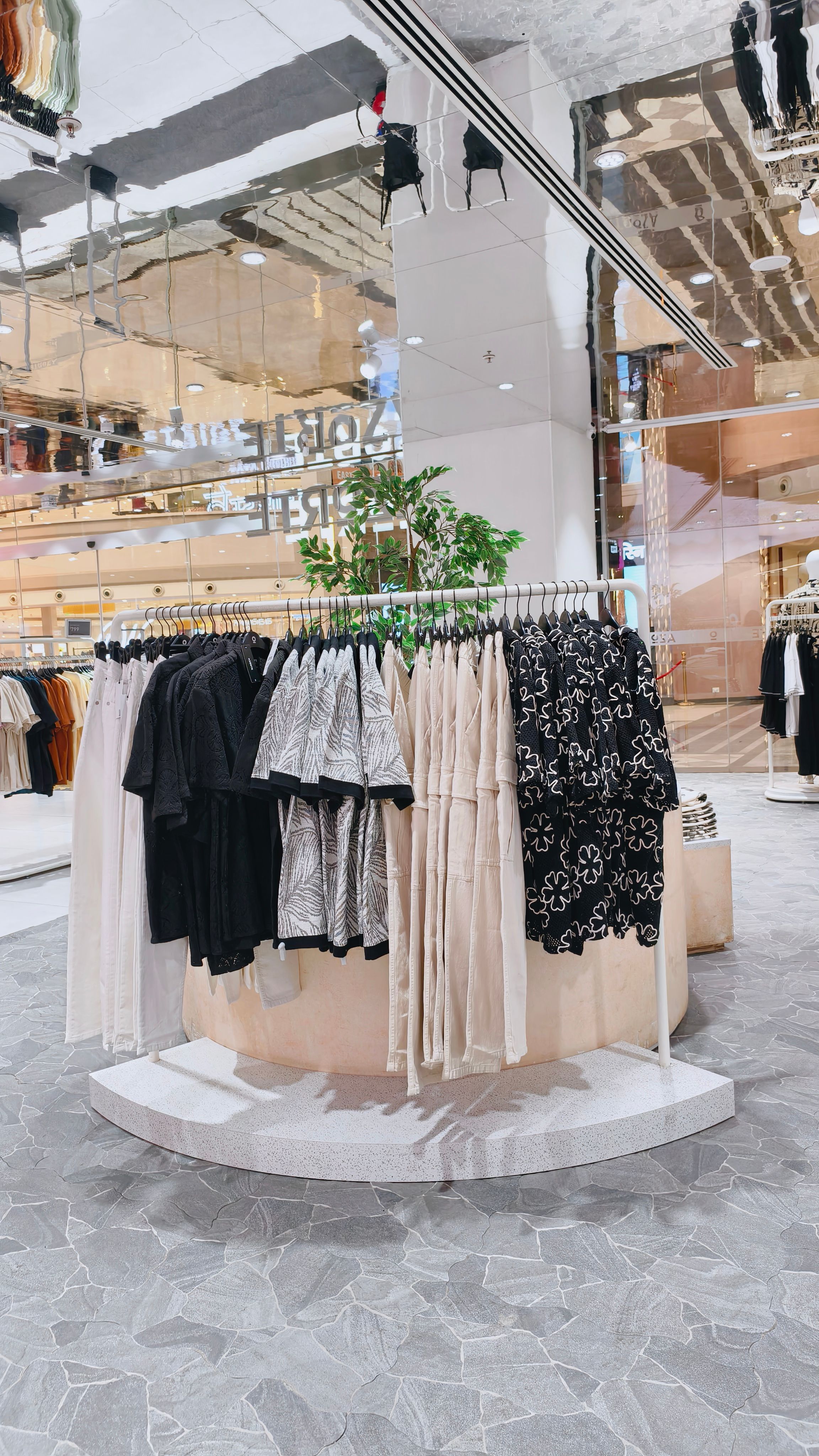 A curated fashion collection displayed on rails inside a modern retail space.